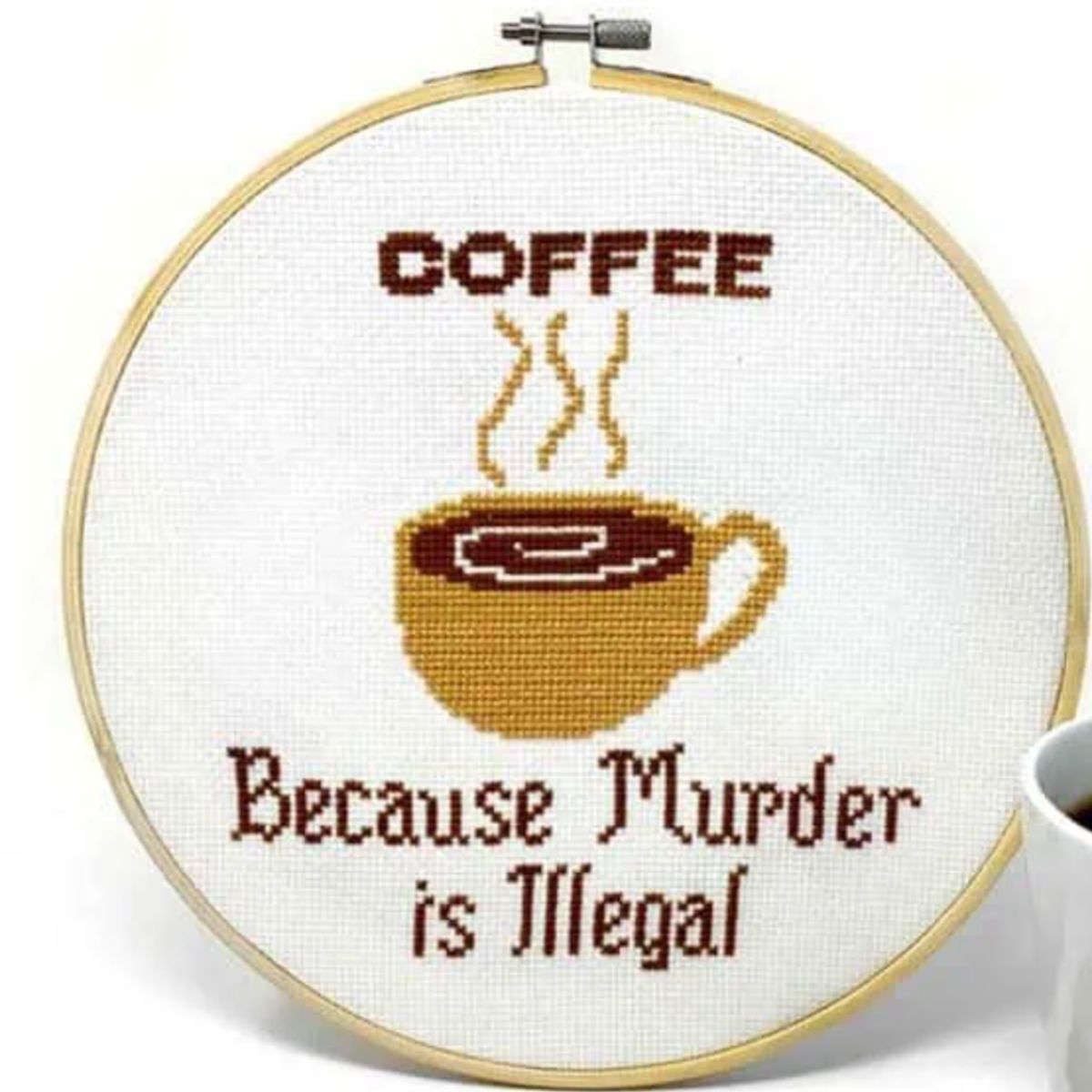 cross stitch project with coffee cup in the middle and words coffee because murder is illegal
