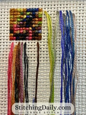Parked threads for a cross stitch project on Aida