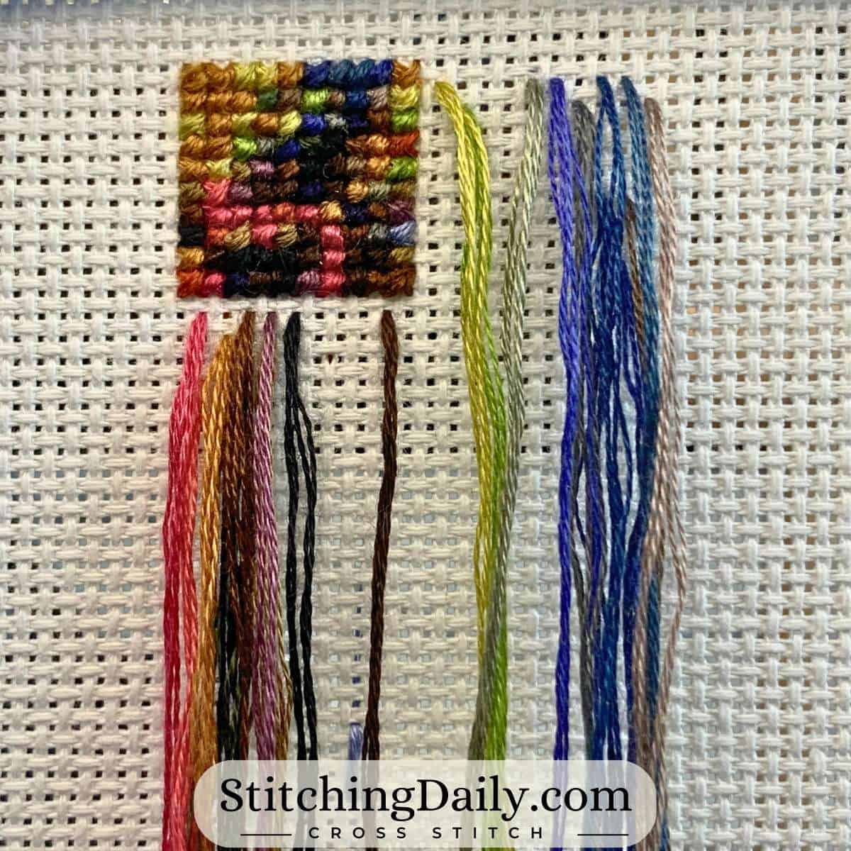 Parked threads for a cross stitch project on Aida